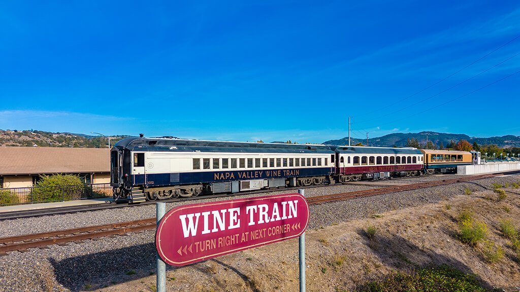A train with a sign that says Wine Train is on the tracks
